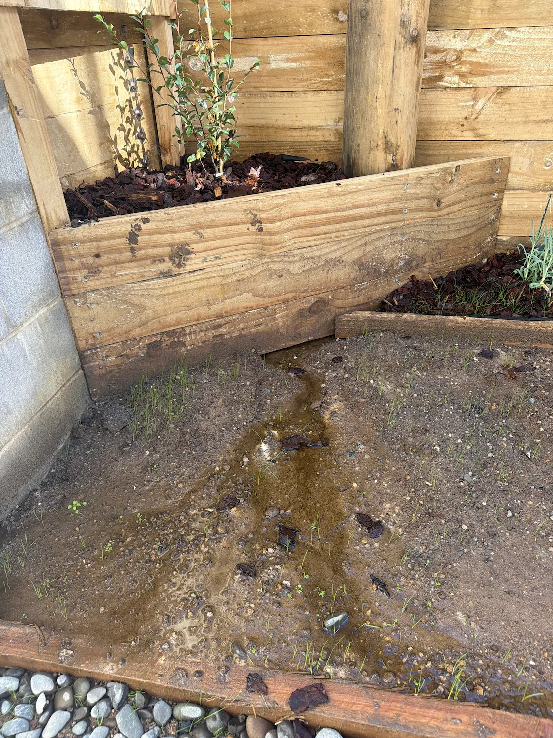 Water discharging from retaining wall area and flowing towards new townhouse slab